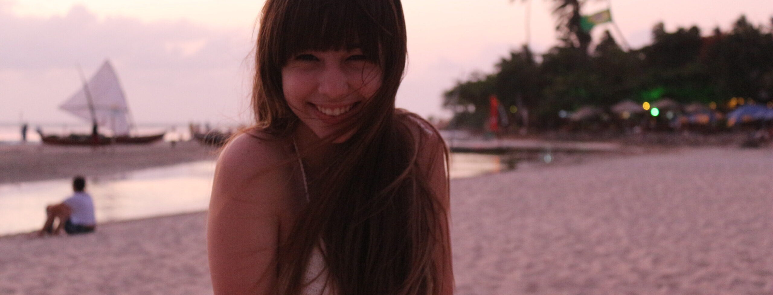 Girl smiling at the beach in Jericoacoara practicing mindful travel.