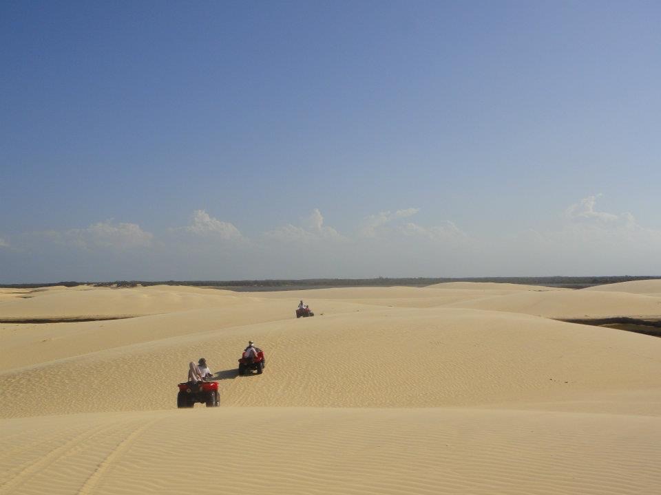 Three ATV vehicles with tourists driving through the dunes of Lencois Maranhenses