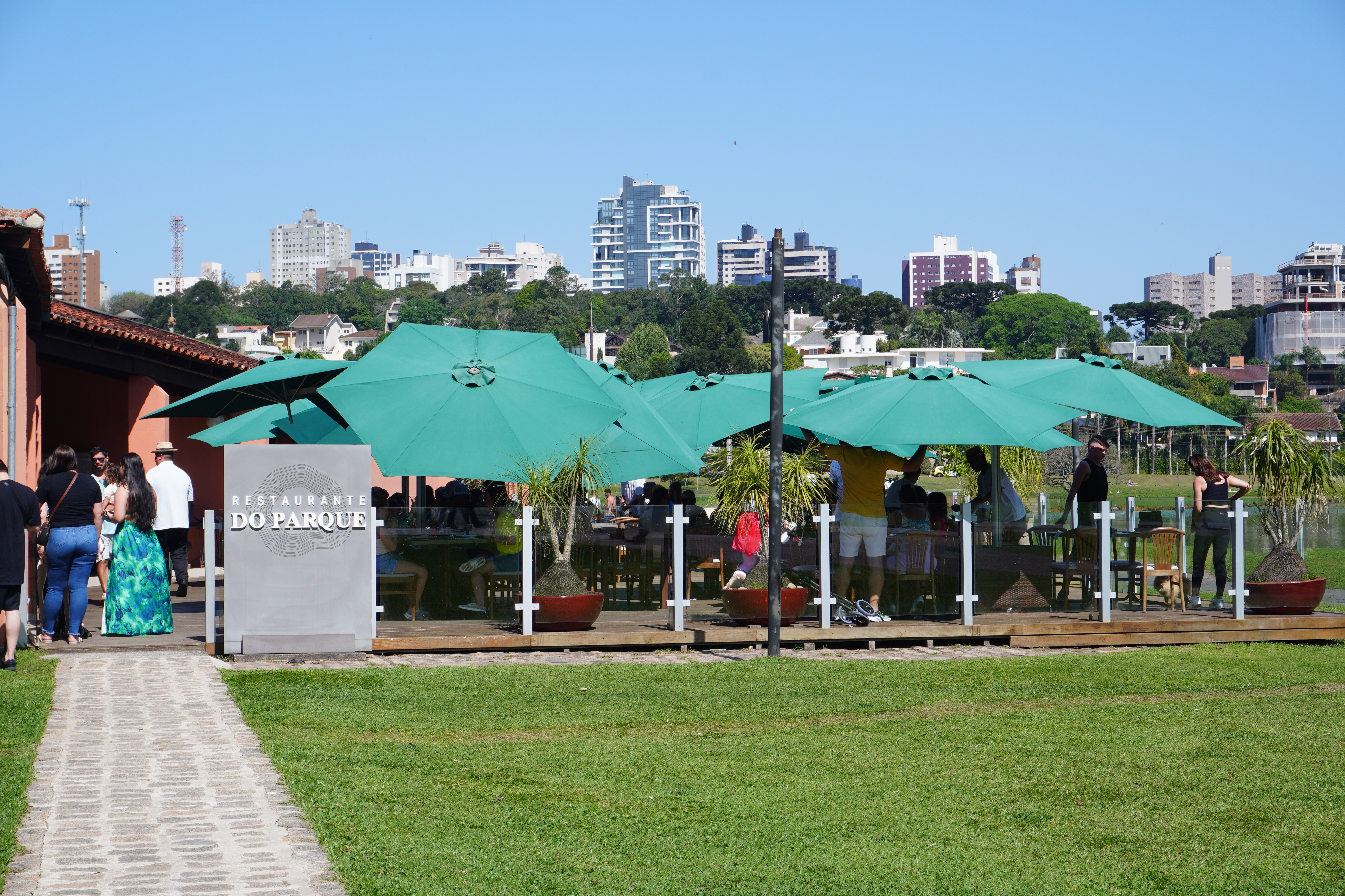 Outdoor restaurant seating with many green umbrellas to prodtect visitors from the sun