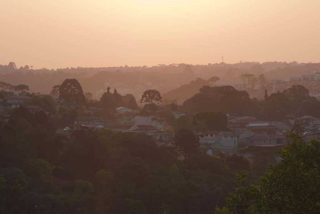 Orange sunset tones contrasting with local trees and homes