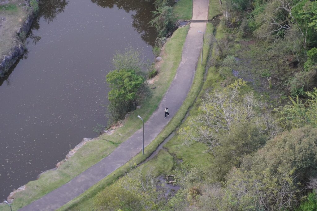 Woman running at a trail by the lake at Parque Tangua