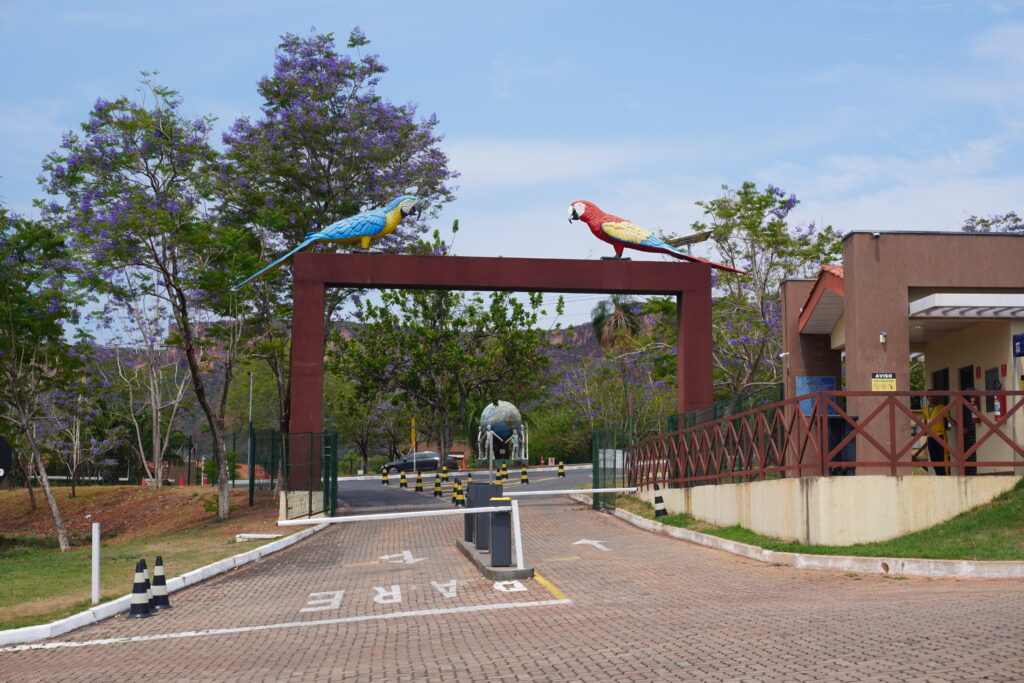 Car entrance to the Complexo da Salgadeira at Chapada dos Guimaraes. The structure of the entrance is very modern and well made, and giant macaw sculptures sit on top of the main gate.