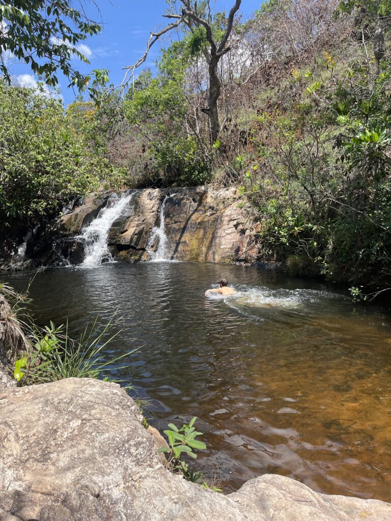 Man swimming inside a waterfall in the Circuito das Cachoeiras