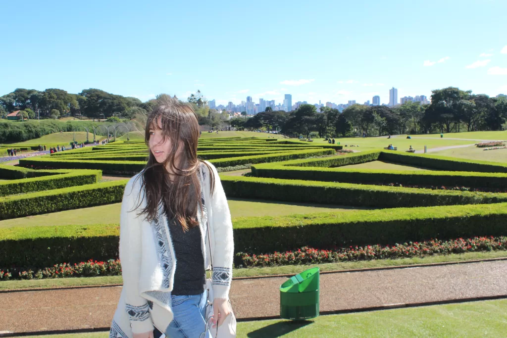 Girl posing in front of Curitiba's french garden. In the back lays the city's skyline.