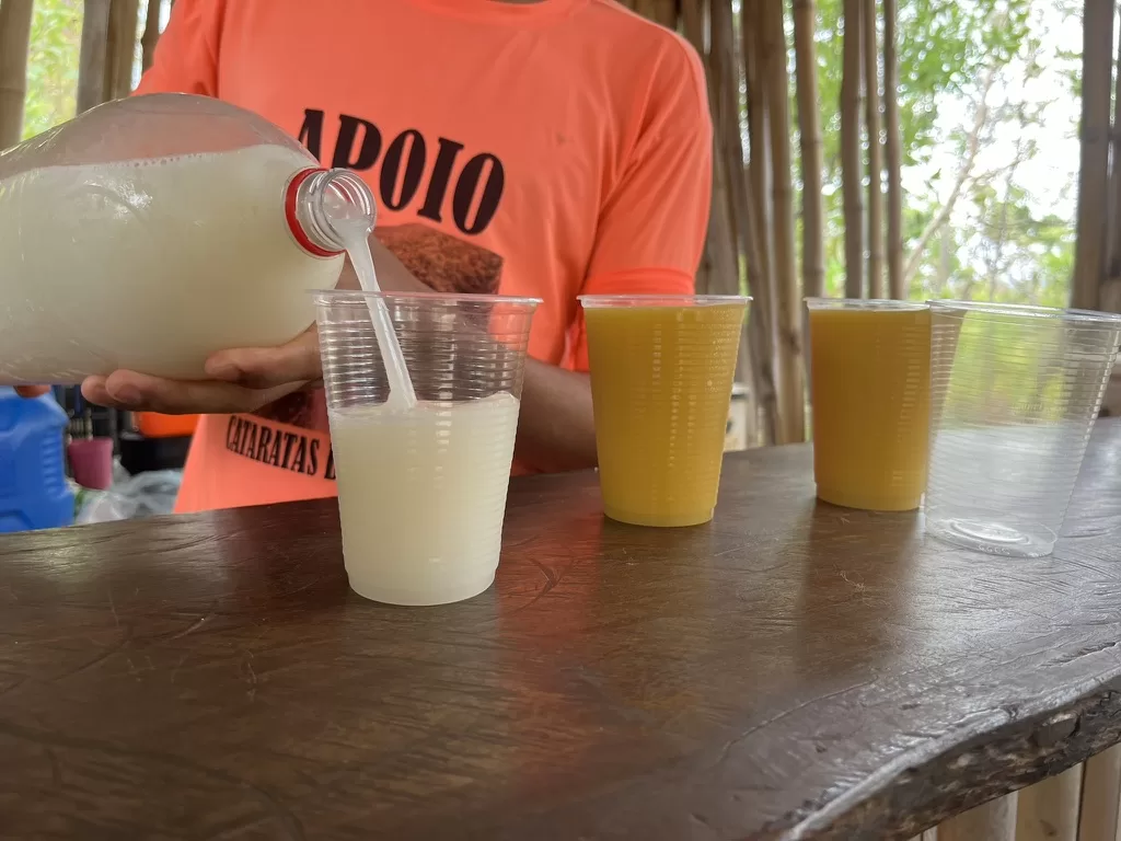 Man serving juices of local fruits in plastic cups