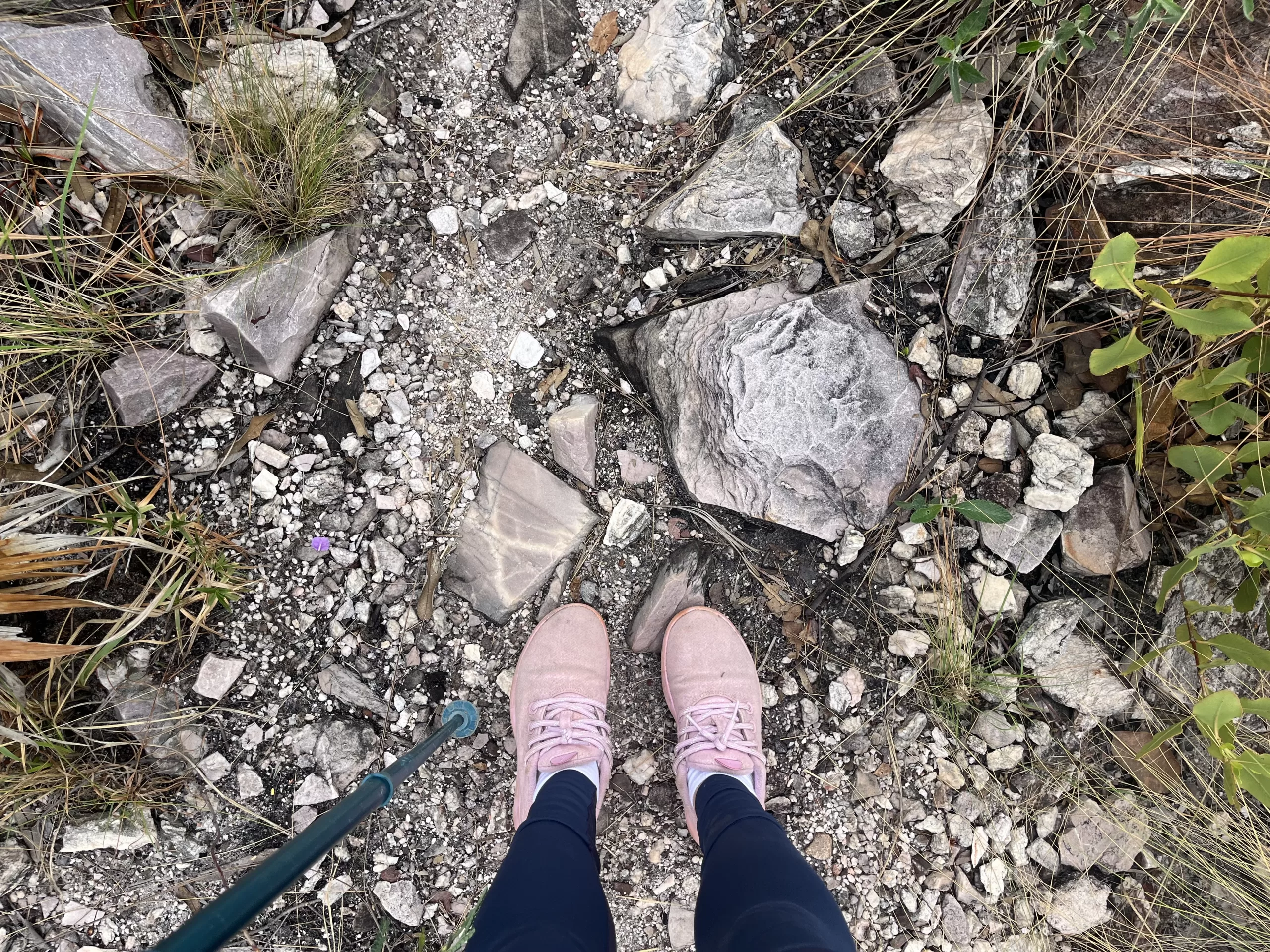 Hiking trail filled with rose-quartz stones and a girl standing on it