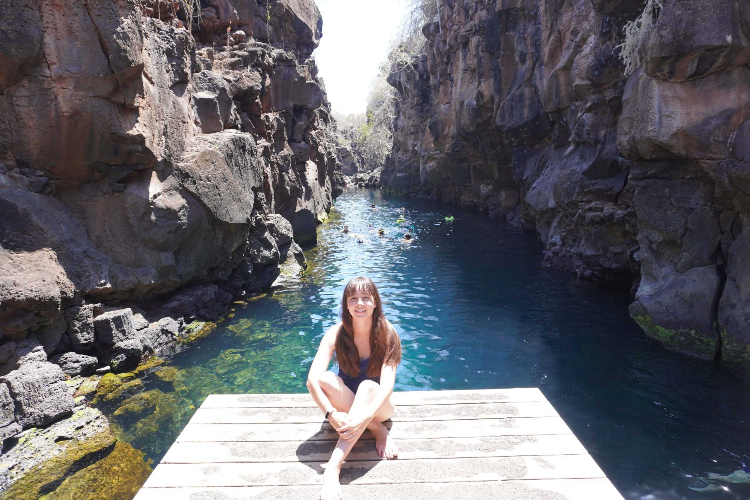 Lo Lee sitting in front of Las Grietas while many snorkelers swim in the back