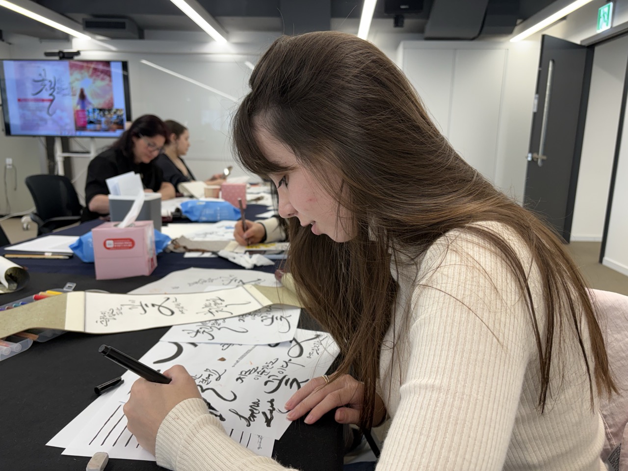 Girl practicing calligraphy in a workshop hosted by the Seoul Culture Lounge