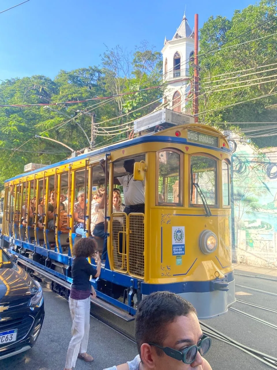 Santa Teresa's iconic yellow cable car stopping for passengers to come in.