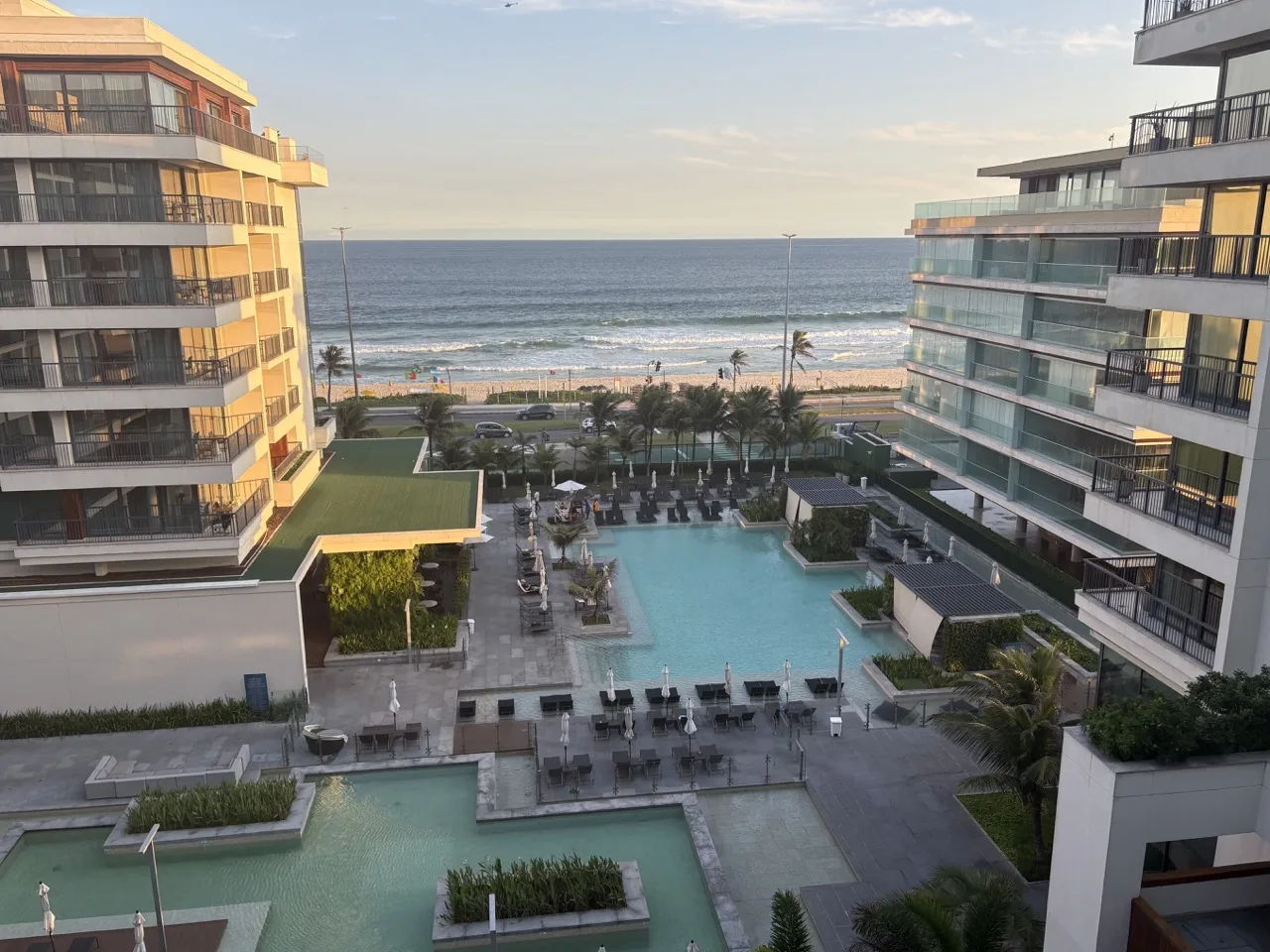 View from a room at the Grand Hyatt Luxury Hotel in Rio de Janeiro. The view includes the hotel facilities, two pools, and the beach on a clear day.