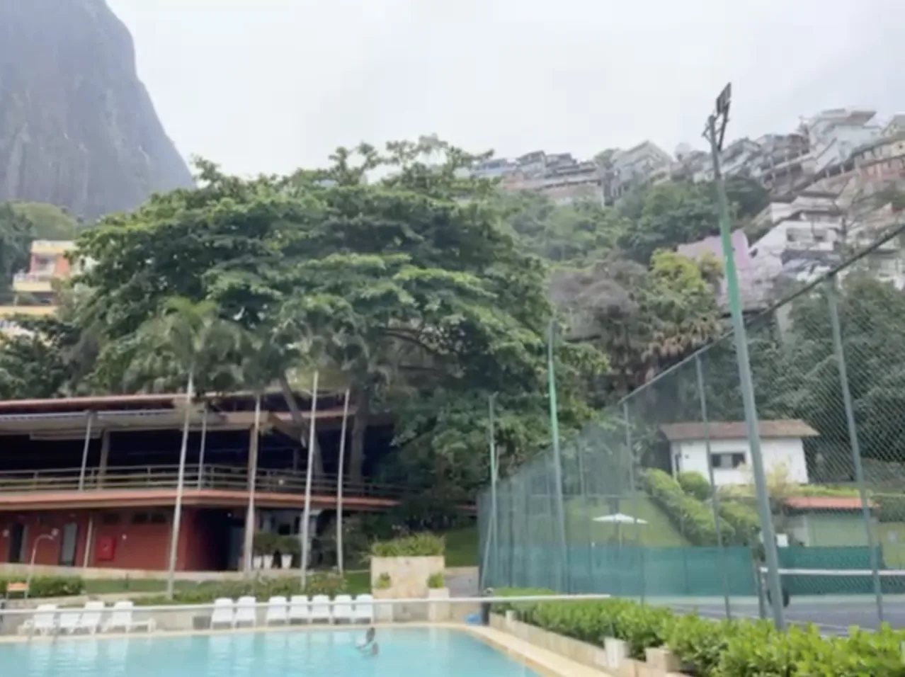 One of the pools at Sheraton Rio, with plastic chairs and surrounded by the Vidigal favela.