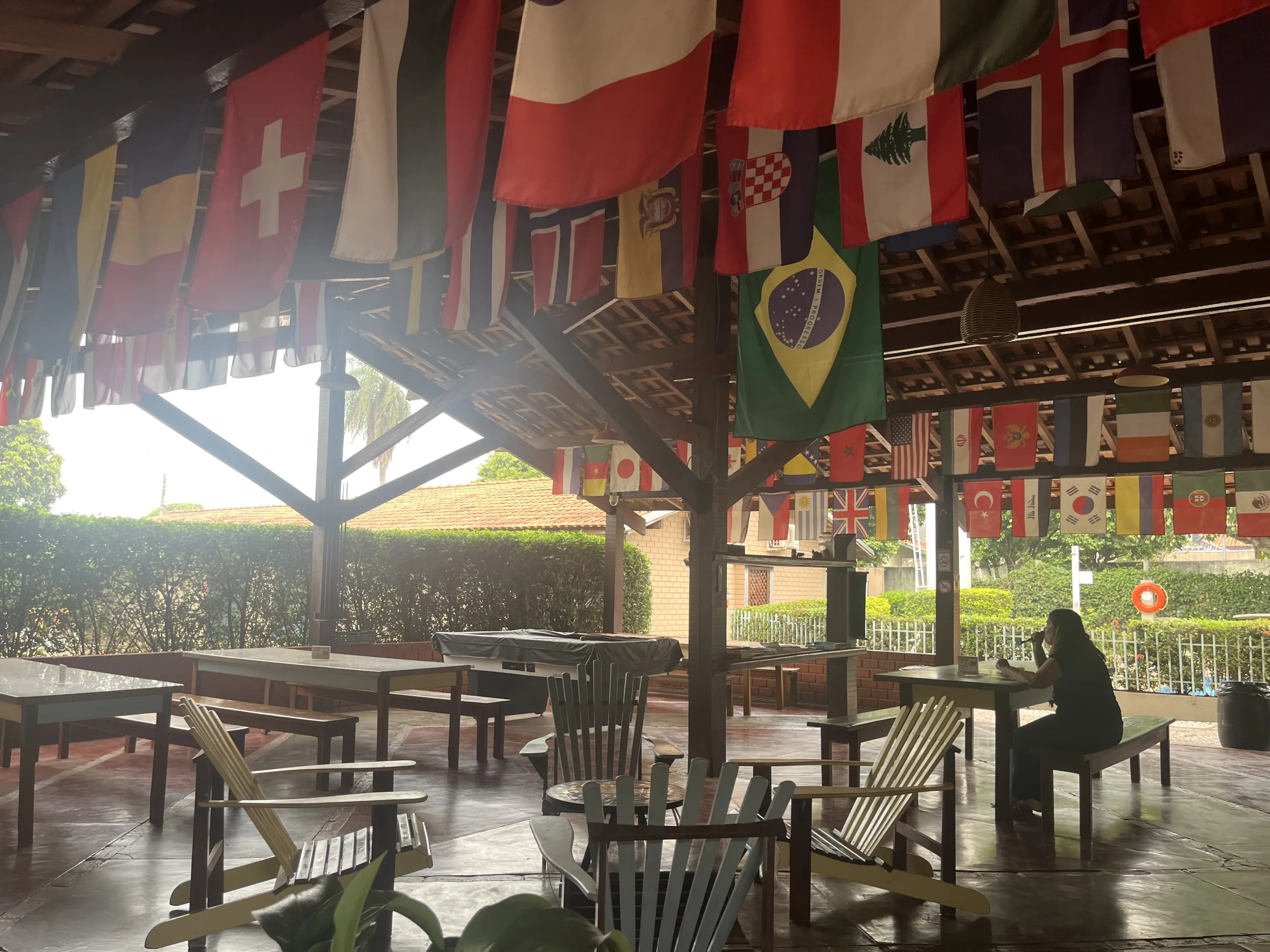 Lunch and communal space at HI Hostel Bonito. The space has a lot of seating and flags of different countries hanging from the ceiling.