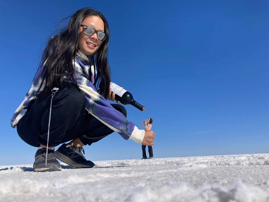 Illusion perspective picture of a giant feeding wine to a little human