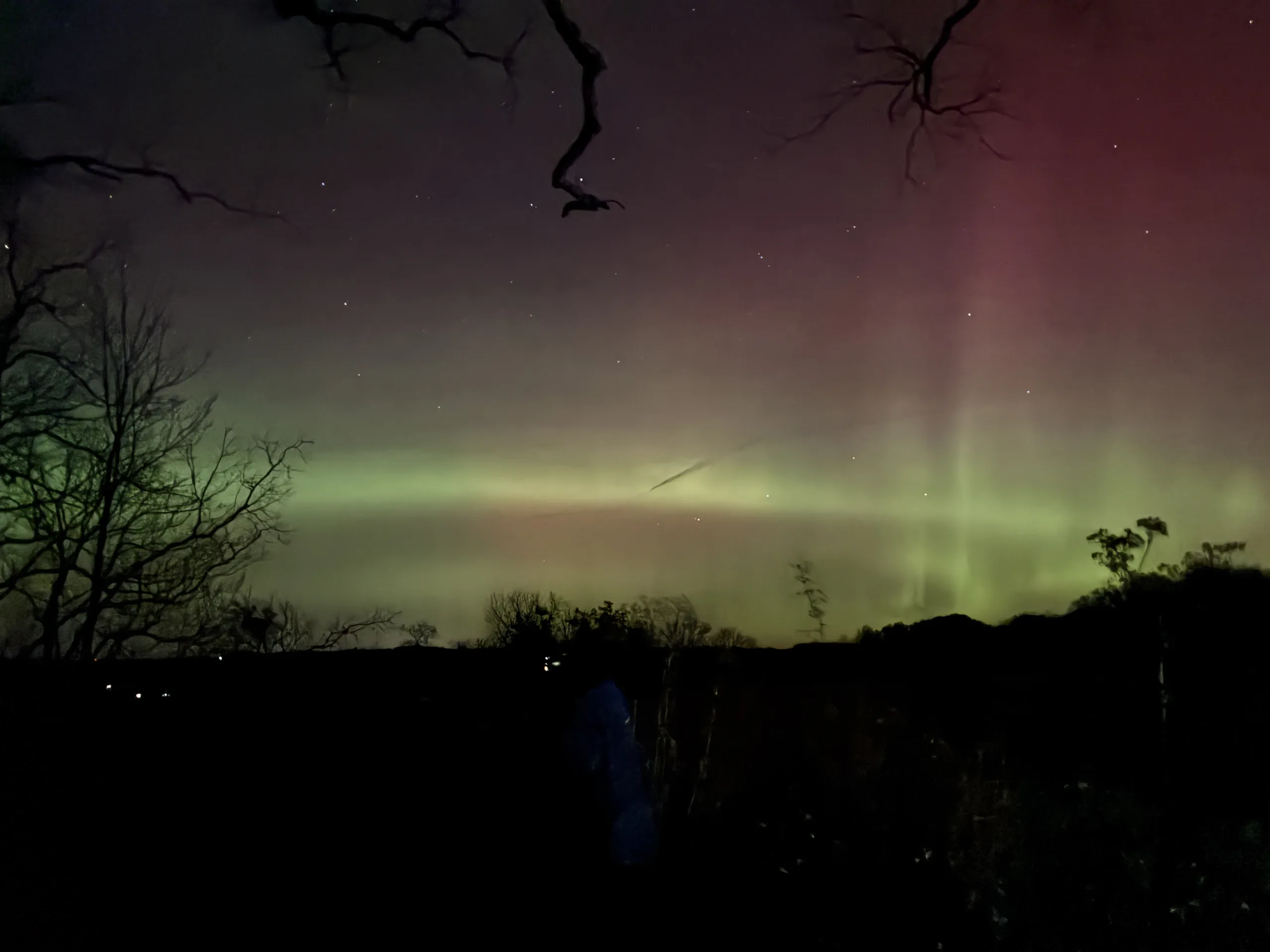 Very bright nothern lights show at Cross Plains. The lights have two bright and thin green strips and a pink tint above it.