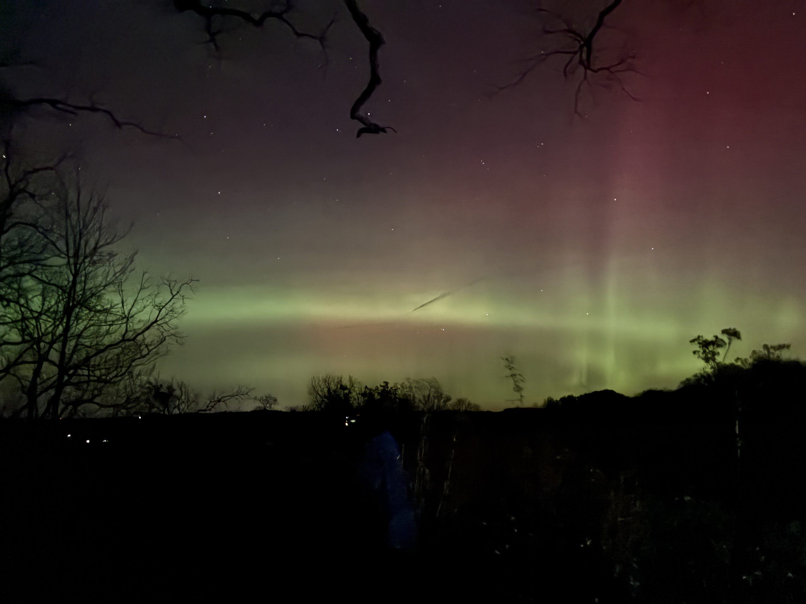 Very bright nothern lights show at Cross Plains. The lights have two bright and thin green strips and a pink tint above it.