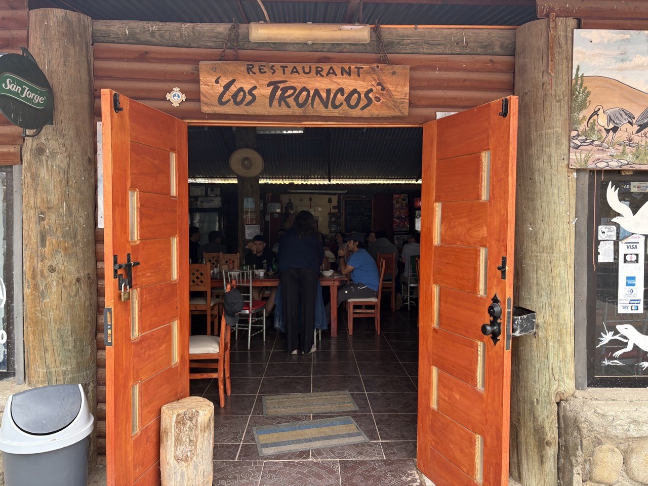 Entrance of the Los Troncos restuarant in Los Choros. Lots of guests are sitting inside and being served.